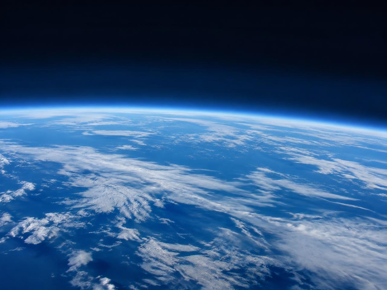 The curve of Earth seen from high altitude with thin cloud layers