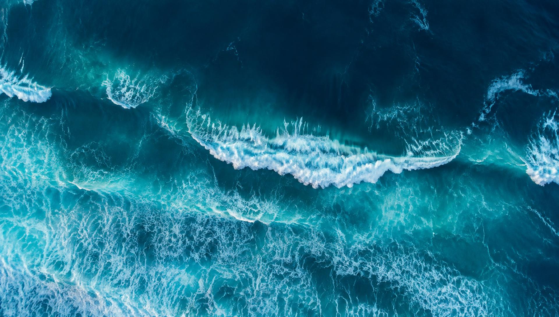 Aerial view of ocean swell and white foam on deep blue water